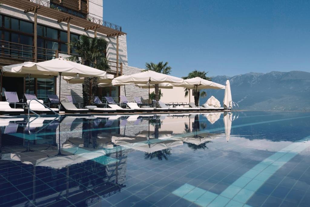 Lefay Resort Lago Garda infinity pool with mountain views, luxury sun loungers and crystal-clear water reflecting blue sky